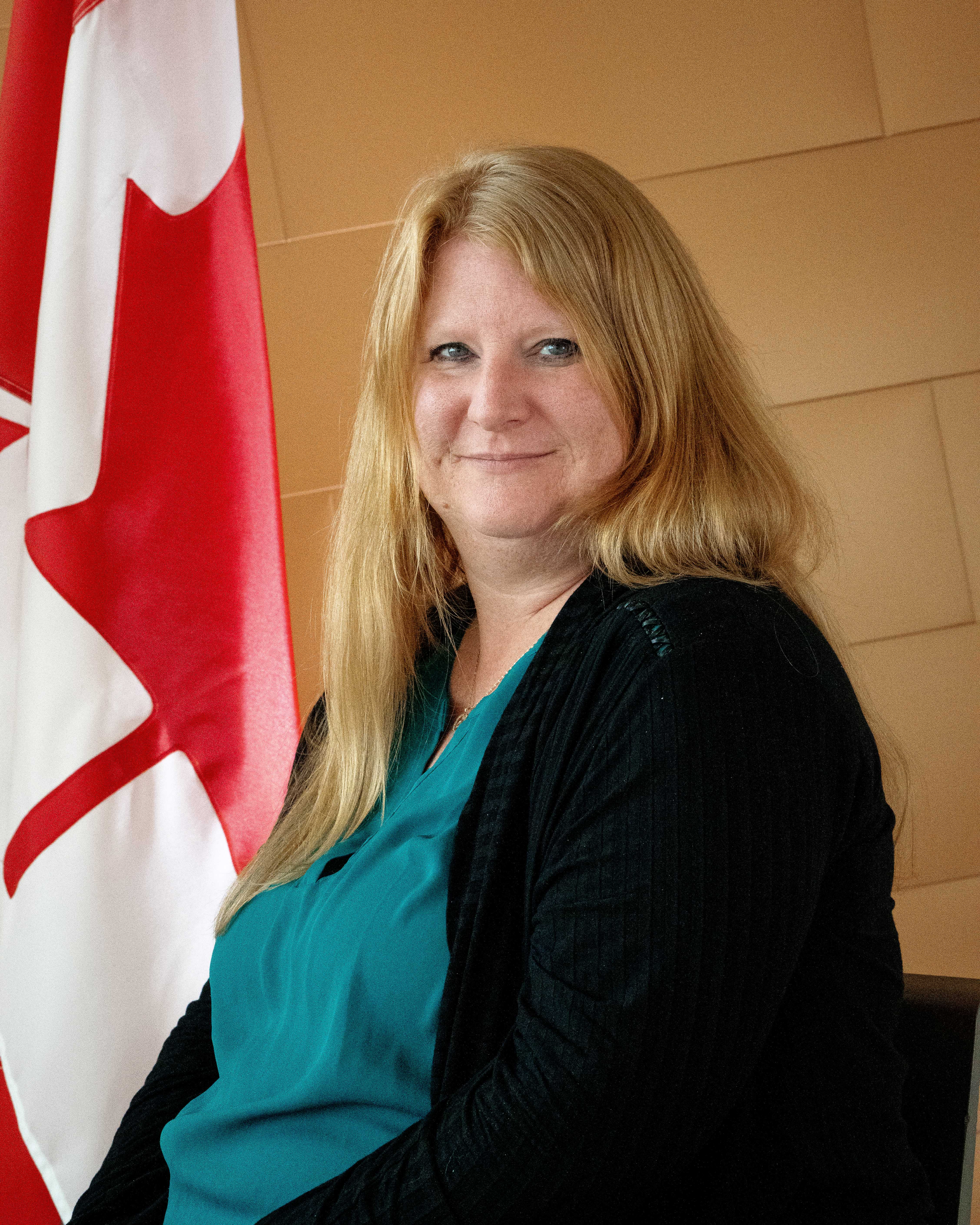 Portrait d’une femme aux cheveux longs qui sourit.